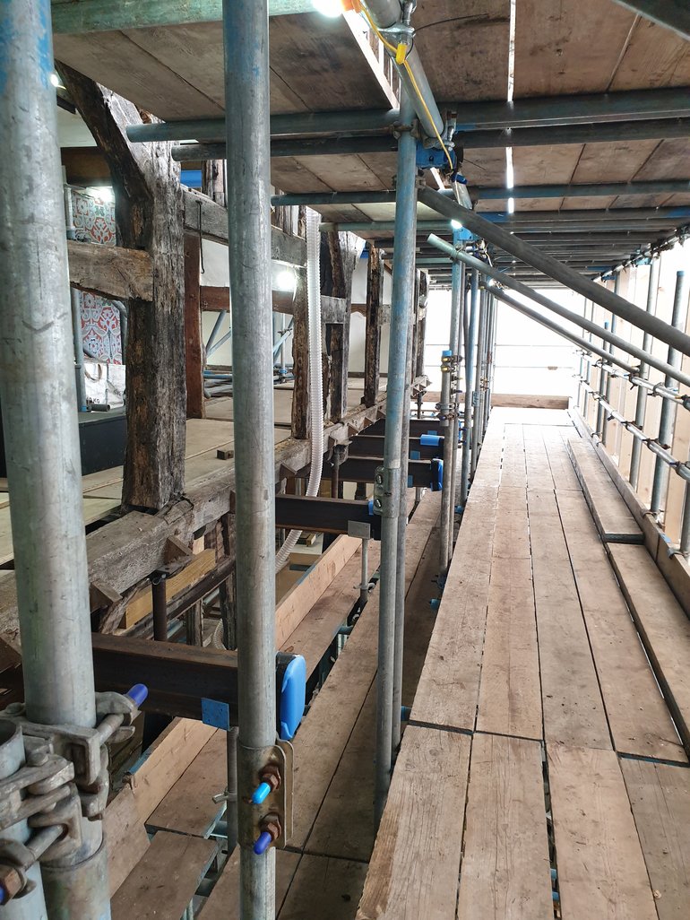 Wooden boards supported by metal upright supports which form part of the scaffolding platform at Hall's Croft